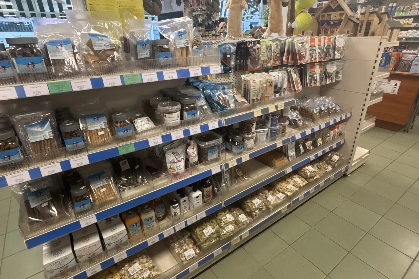 Goed gevulde schappen met hondenvoer en snacks in de winkel